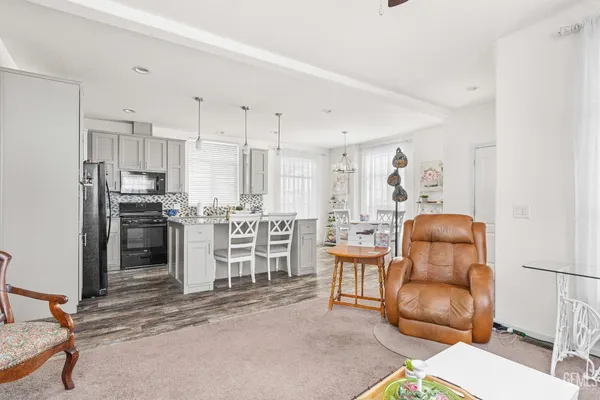 a kitchen with stainless steel appliances kitchen island granite countertop a refrigerator and a sink