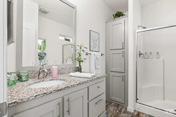a bathroom with a granite countertop sink and a mirror