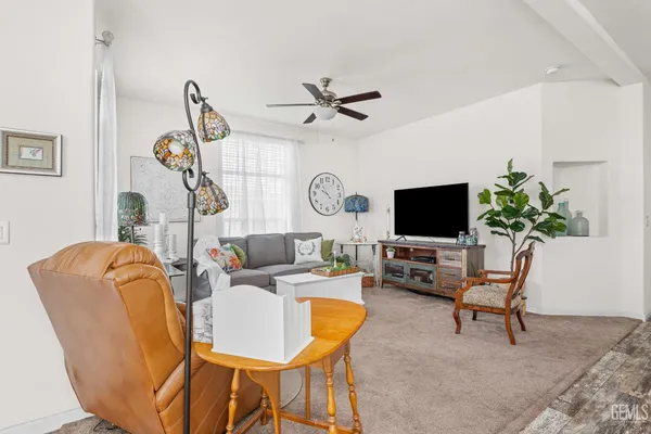 a living room with furniture a flat screen tv and a window