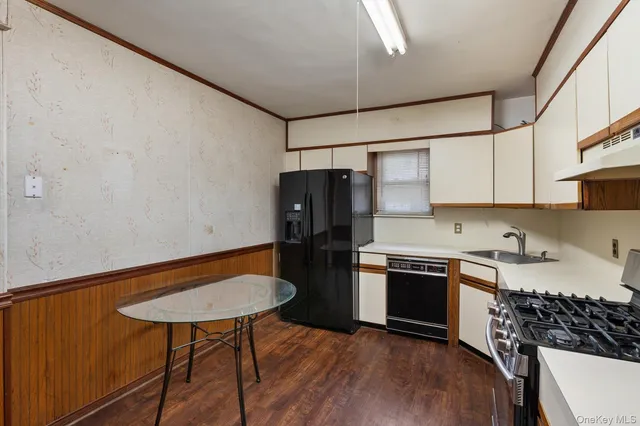 a kitchen with stainless steel appliances granite countertop a refrigerator a stove a sink dishwasher and white cabinets with wooden floor