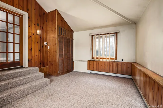 a view of an empty room with windows and stairs