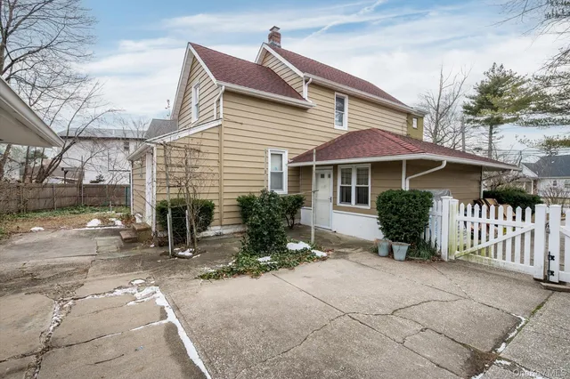 a backyard of a house with table and chairs