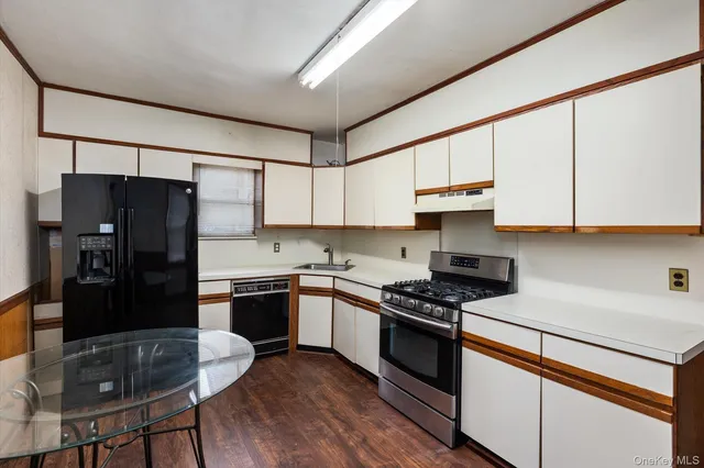 a kitchen with stainless steel appliances granite countertop a refrigerator a stove sink and cabinets