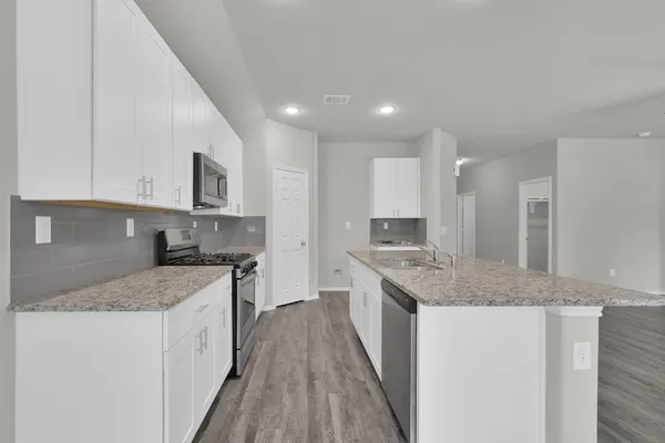 a kitchen with stainless steel appliances granite countertop a sink stove and cabinets