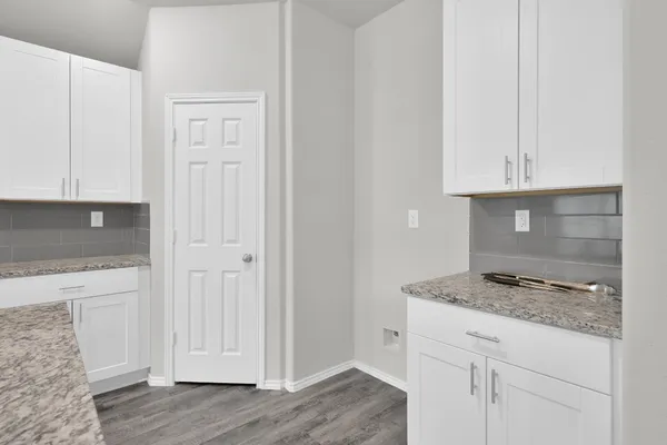 a kitchen with granite countertop white cabinets and a stove