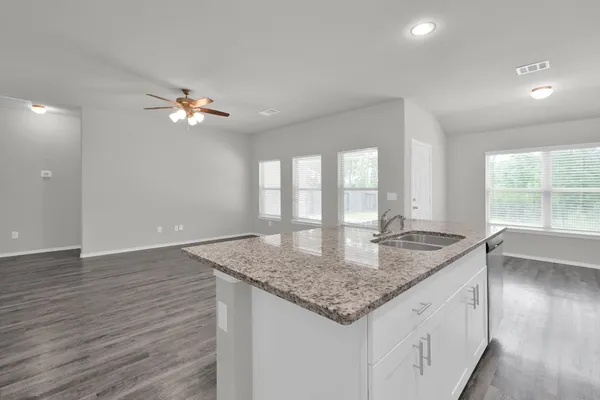 a bathroom with a granite countertop sink and a window