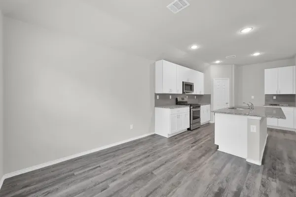 a kitchen with a refrigerator and white cabinets