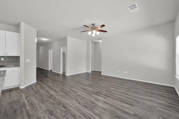 a view of empty room with wooden floor