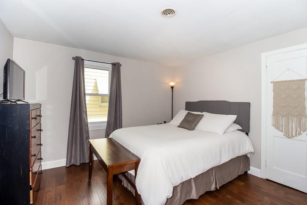75 Garland Street Springfield, MA 01118 - Photo 18 of 32 a bedroom with a bed table and a large mirror