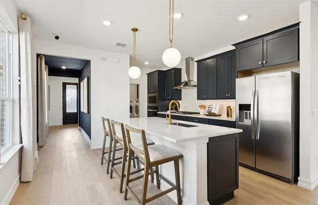 a kitchen with stainless steel appliances a refrigerator a stove a sink and a refrigerator