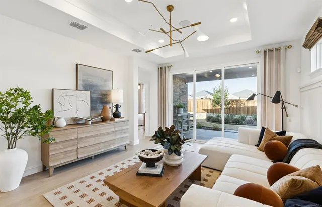 a living room with furniture potted plant and a large window