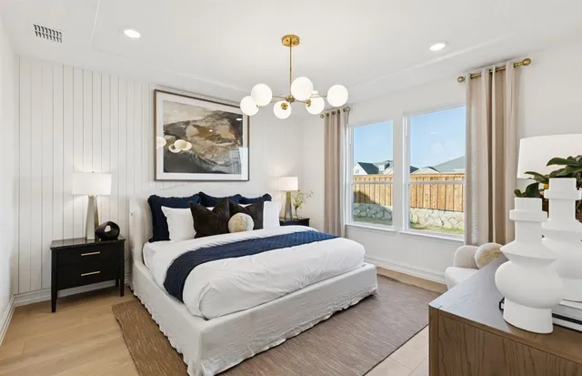 a spacious bedroom with a bed and a chandelier