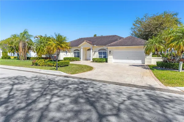a view of a house with a yard and palm trees