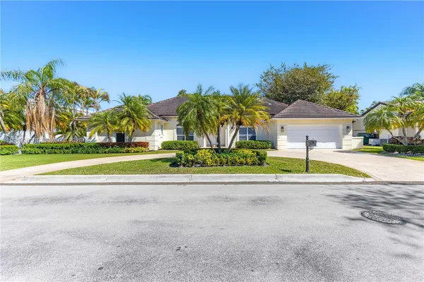 a palm tree sitting in front of a house with a yard