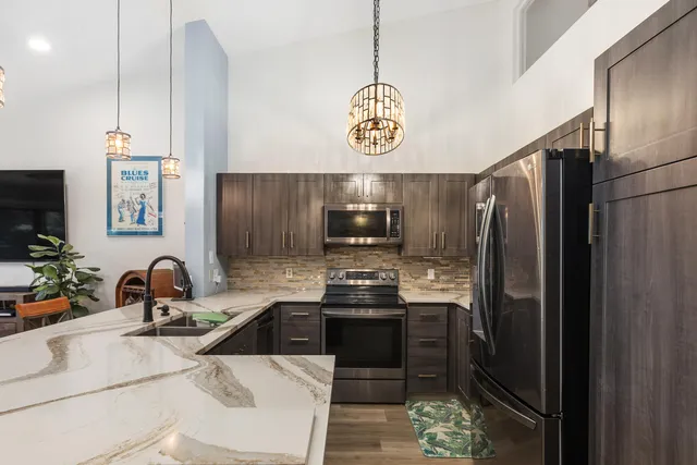 a kitchen with stainless steel appliances a sink stove and refrigerator
