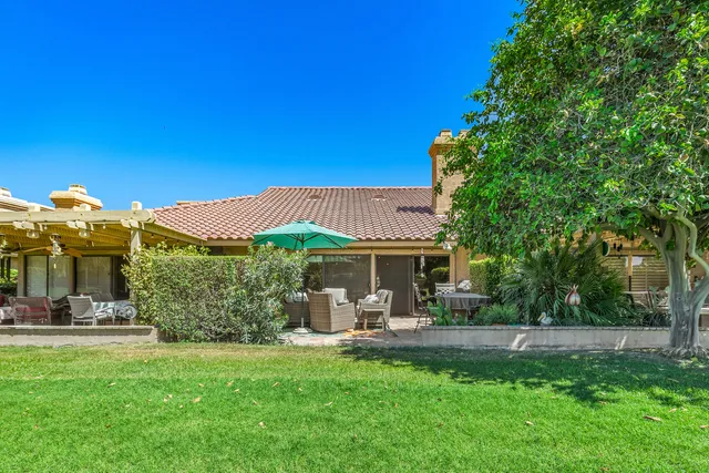a view of a patio with table and chairs under an umbrella