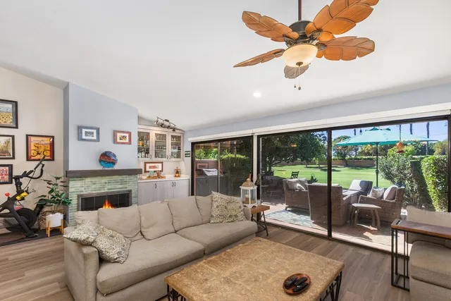 a living room with furniture fireplace and a large window