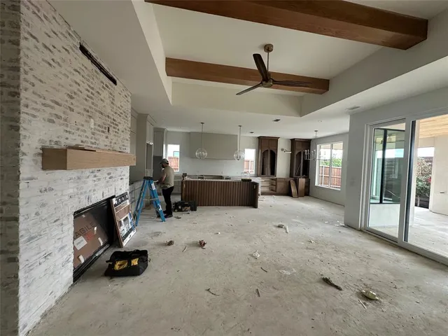 a view of a livingroom with fireplace and a ceiling fan