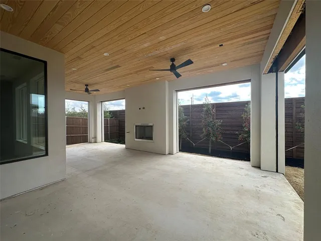 a view of an empty room with windows and chandelier