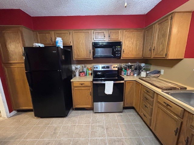 1908 Chelsea Court Rosenberg, TX 77471 - Photo 4 of 9 a kitchen with stainless steel appliances granite countertop a refrigerator stove and sink