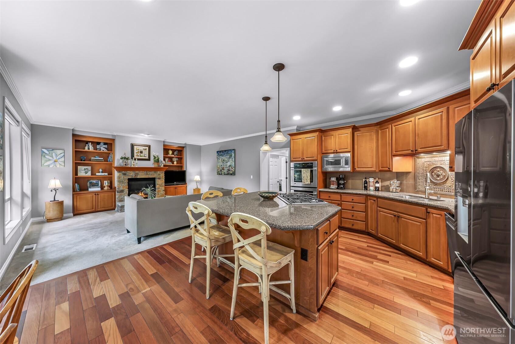 2029 240th Place Southeast Bothell, WA 98021 - Photo 13 of 39 a kitchen with stainless steel appliances granite countertop a kitchen island hardwood floor and a view of living room