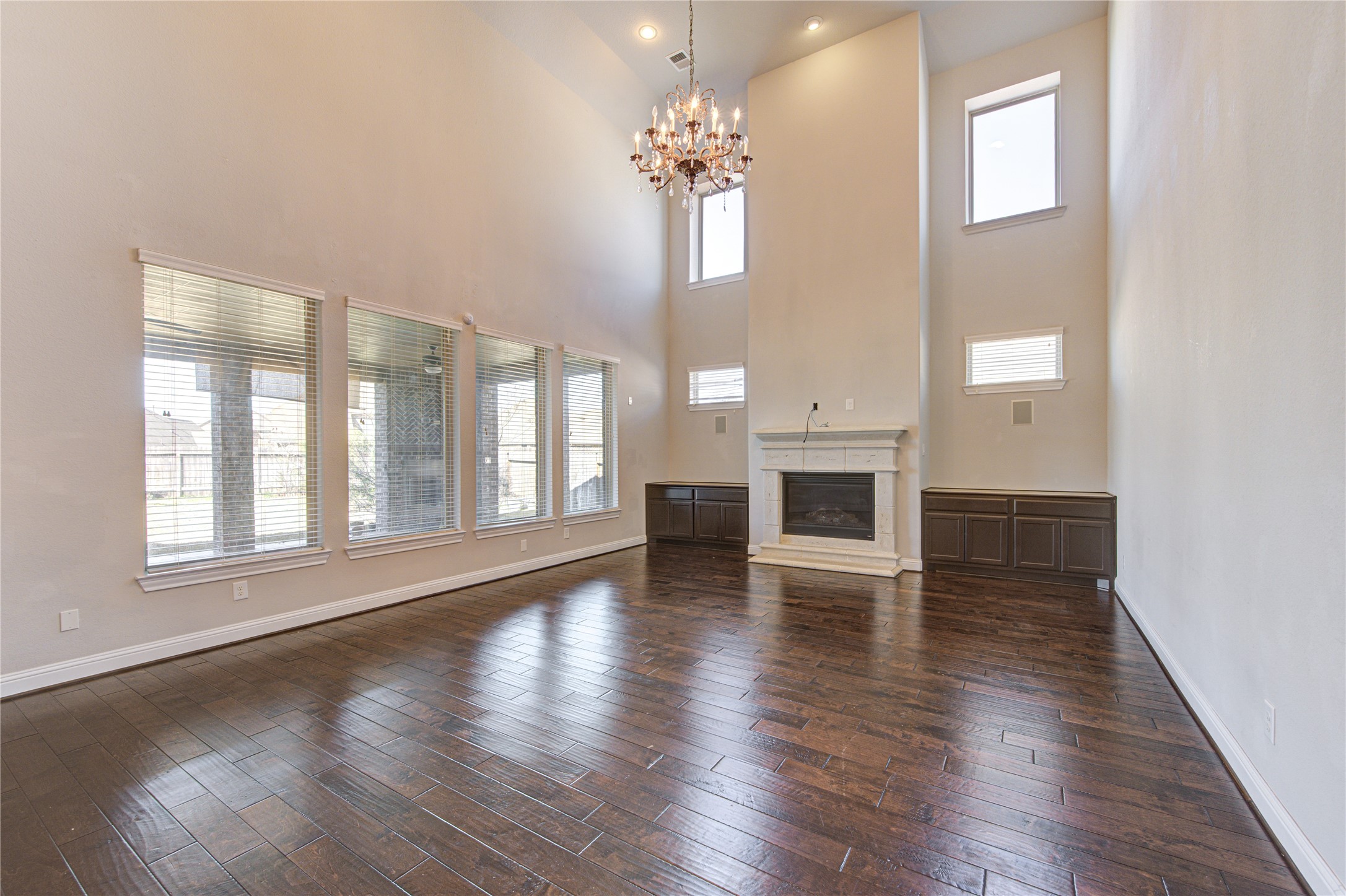 20411 Fawn Rest Place Spring, TX 77379 - Photo 22 of 50 an empty room with wooden floor chandelier and windows
