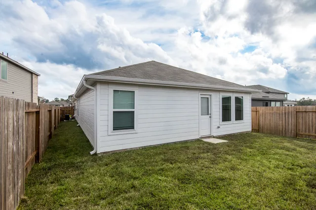 a view of backyard with wooden fence