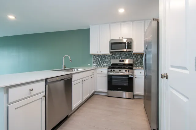 a kitchen with stainless steel appliances granite countertop a stove and a sink