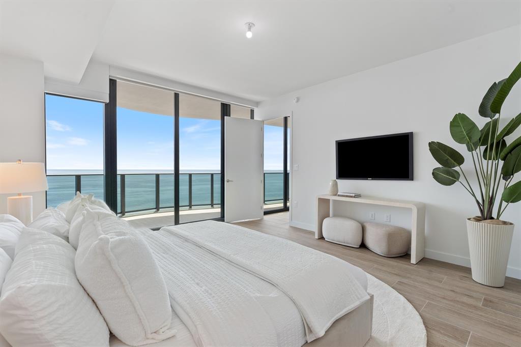 900 North Ocean Boulevard, Unit 1702 Pompano Beach, FL 33062 - Photo 26 of 49 a bedroom with a large bed and a flat screen tv