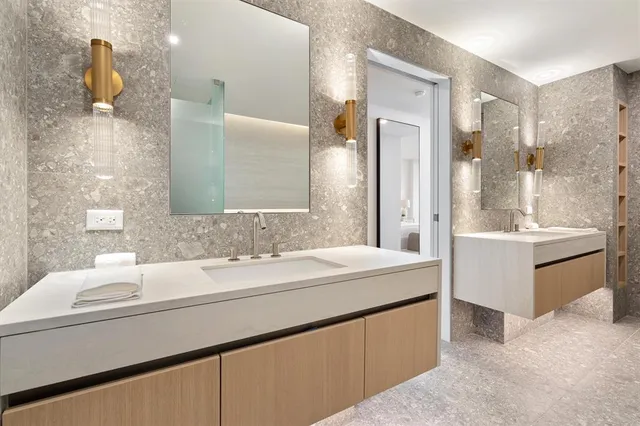 a bathroom with a double vanity sink mirror and bathtub