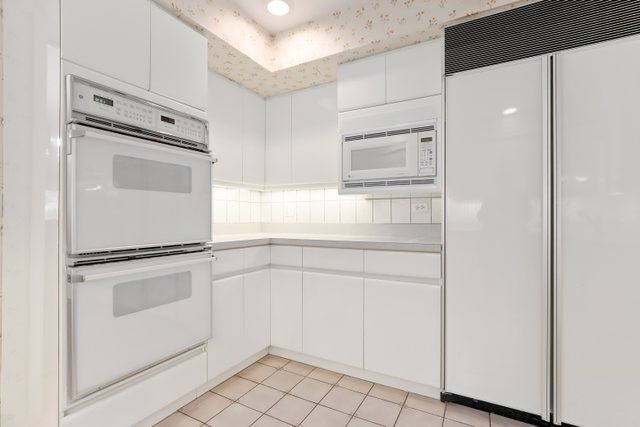 1 North Dee Road, Unit 2D Park Ridge, IL 60068 - Photo 18 of 38 a kitchen with white cabinets and white appliances