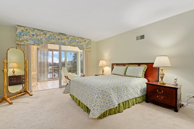 1 North Dee Road, Unit 2D Park Ridge, IL 60068 - Photo 28 of 38 a bedroom with a bed a mirror on table and a large window
