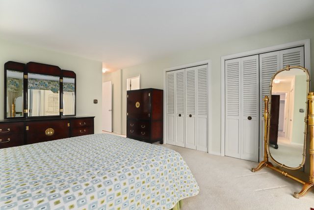 1 North Dee Road, Unit 2D Park Ridge, IL 60068 - Photo 29 of 38 a bedroom with a bed and a dresser with mirror