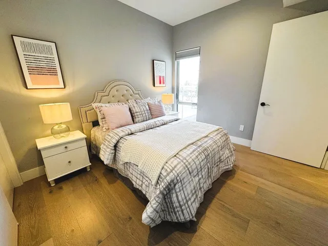 a bedroom with a bed and wooden floor