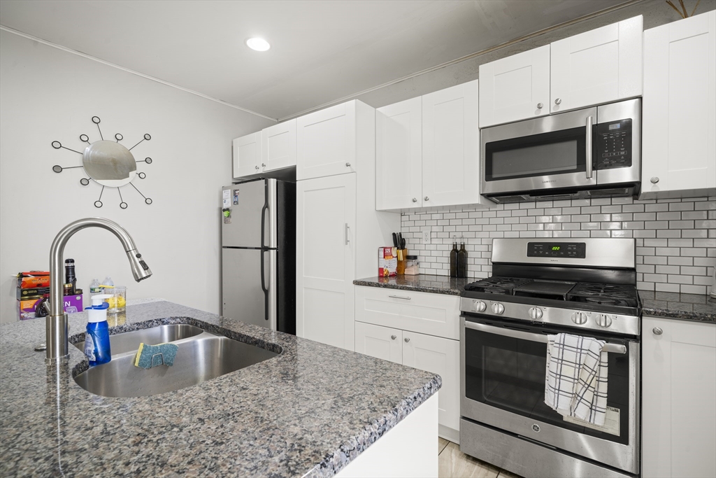 3 Cleveland Street Springfield, MA 01104 - Photo 6 of 14 a kitchen with stainless steel appliances granite countertop a sink stove and microwave
