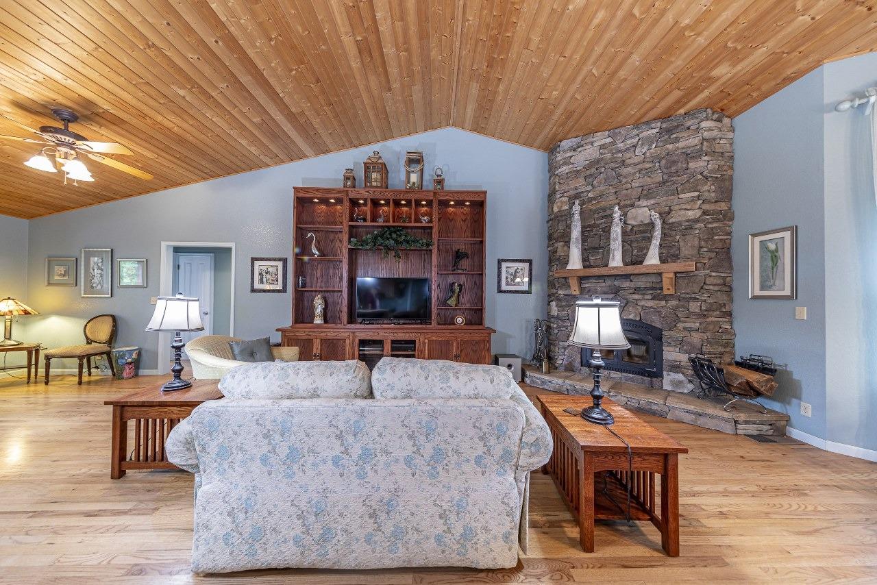 53312 Timberview Road North Fork, CA 93643 - Photo 11 of 84 a living room with furniture a fireplace and a dining table with wooden floor