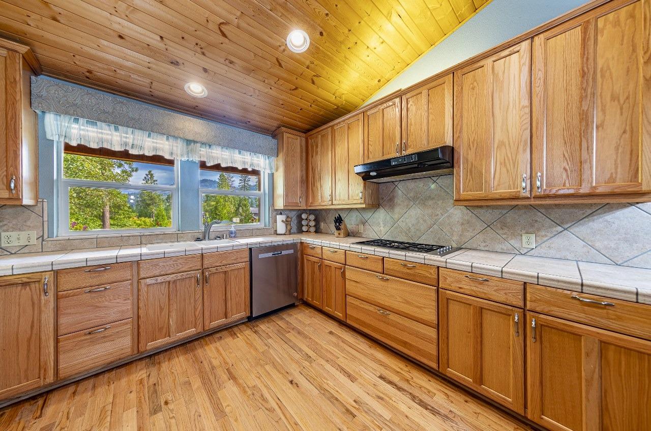 53312 Timberview Road North Fork, CA 93643 - Photo 22 of 84 a kitchen with stainless steel appliances granite countertop wooden cabinets a sink and dishwasher with wooden floor