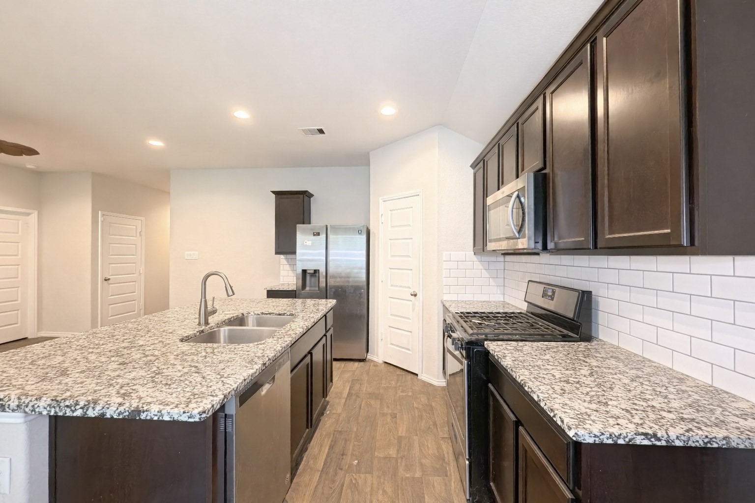 8522 Sacred Lotus Lane Rosharon, TX 77583 - Photo 7 of 11 a kitchen with granite countertop kitchen island stainless steel appliances a sink stove and cabinets