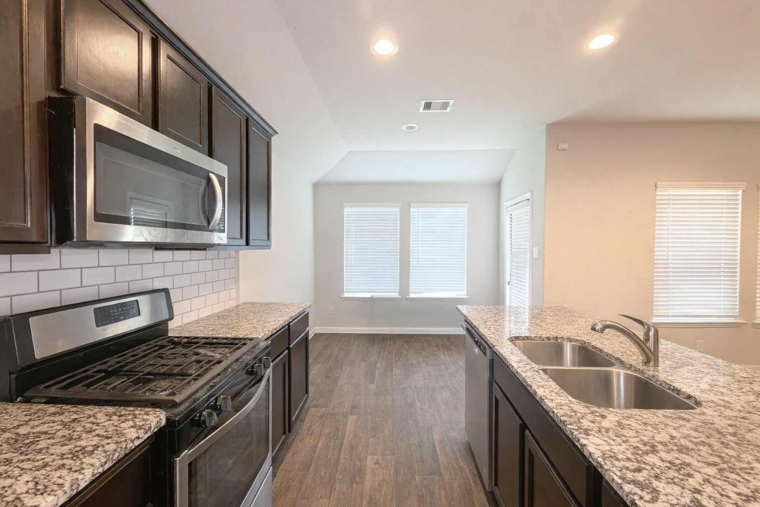 8522 Sacred Lotus Lane Rosharon, TX 77583 - Photo 8 of 11 a kitchen with granite countertop a sink dishwasher stove and cabinets