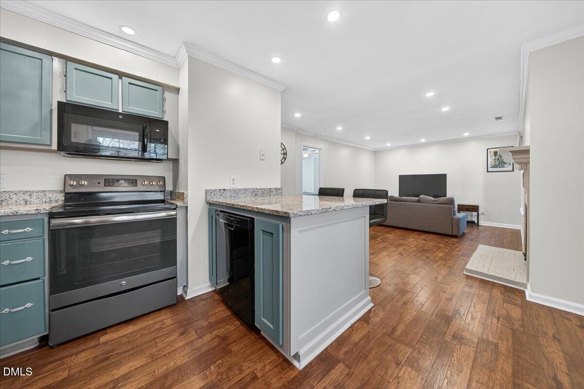 503 Gooseneck Drive, Unit A1 Cary, NC 27513 - Photo 10 of 37 a kitchen with stainless steel appliances kitchen island granite countertop a stove top oven and sink