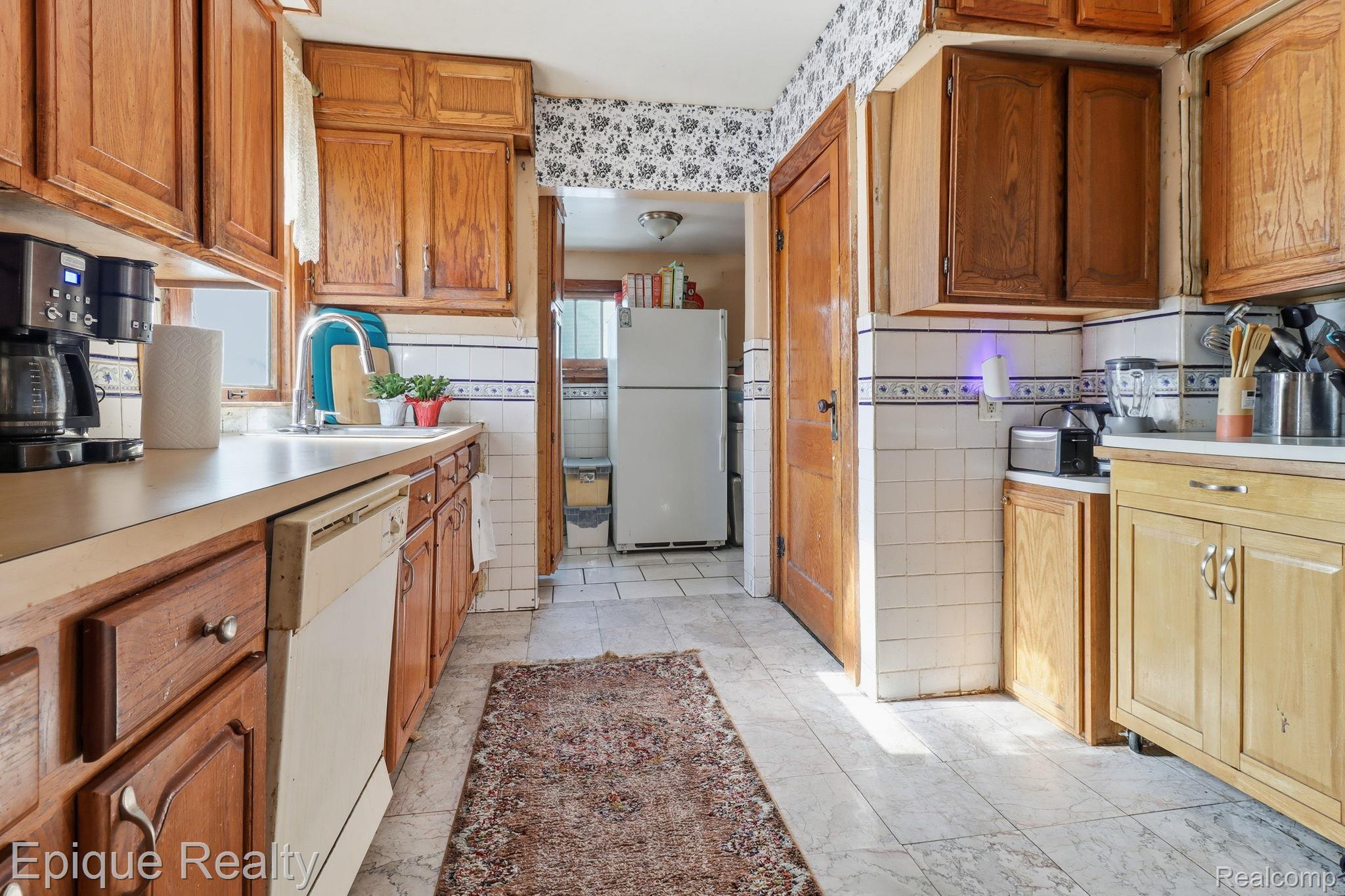 5834 Wayne Road Romulus, MI 48174 - Photo 8 of 15 Kitchen with white appliances, wood finish cabinetry, light countertops, and tile walls