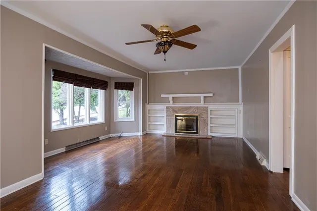 a view of empty room with wooden floor and fireplace