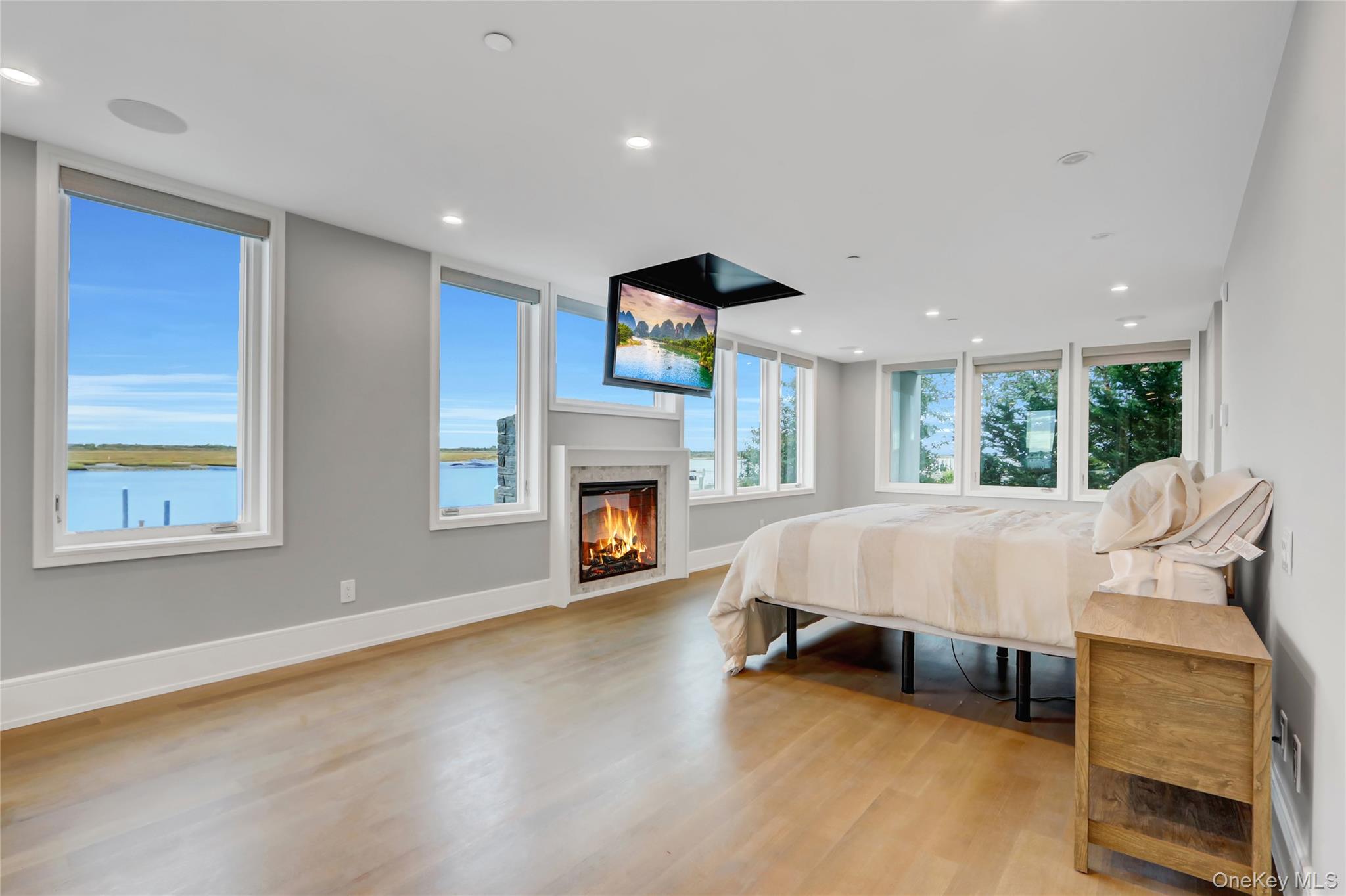 44 Bayside Drive Point Lookout, NY 11569 - Photo 28 of 47 Bedroom with light wood-style flooring, a glass covered fireplace, and recessed lighting