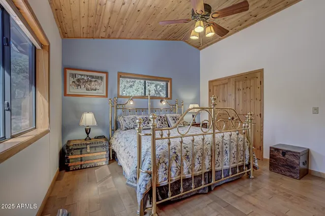 a bedroom with a bed dresser and a flat tv screen