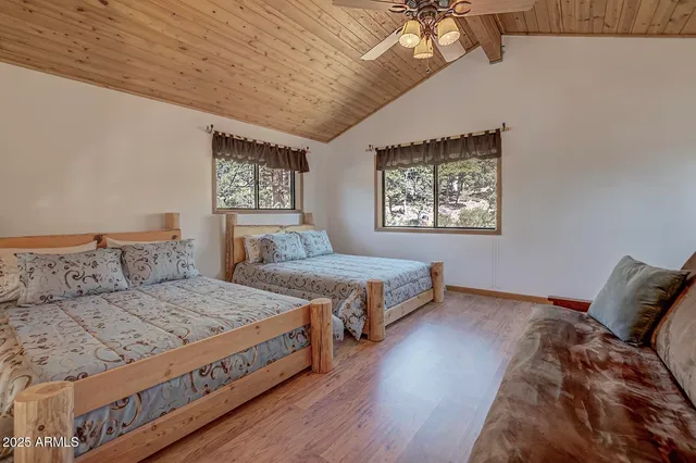 a bedroom with a large bed a chandelier and windows