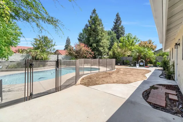a view of a house with pool and a yard