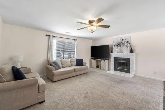 a living room with furniture a fireplace and a flat screen tv
