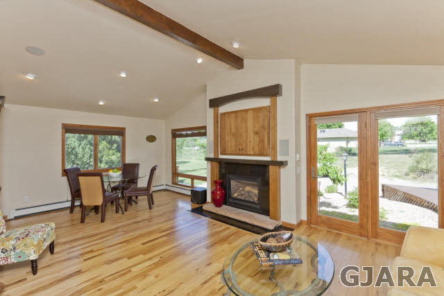 2638 H Road Grand Junction, CO 81506 - Photo 6 of 36 a living room with furniture a fireplace and a floor to ceiling window