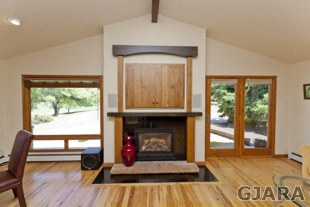 2638 H Road Grand Junction, CO 81506 - Photo 8 of 36 a living room with a fireplace and a floor to ceiling window