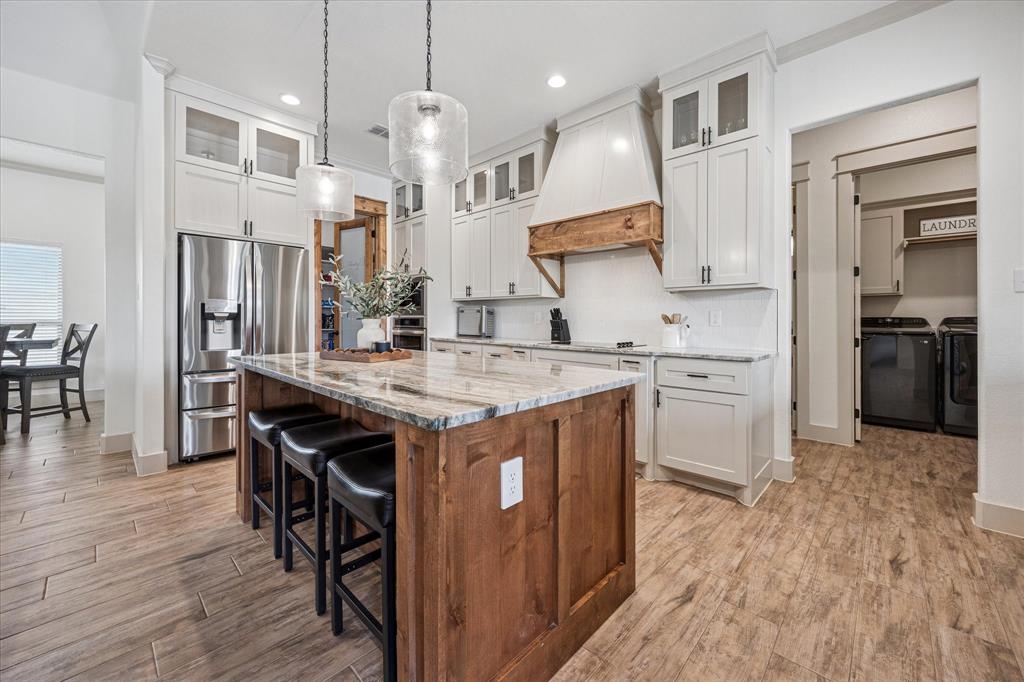 2028 Carrie Court Weatherford, TX 76088 - Photo 13 of 40 a kitchen with granite countertop a sink appliances a counter space and wooden floor